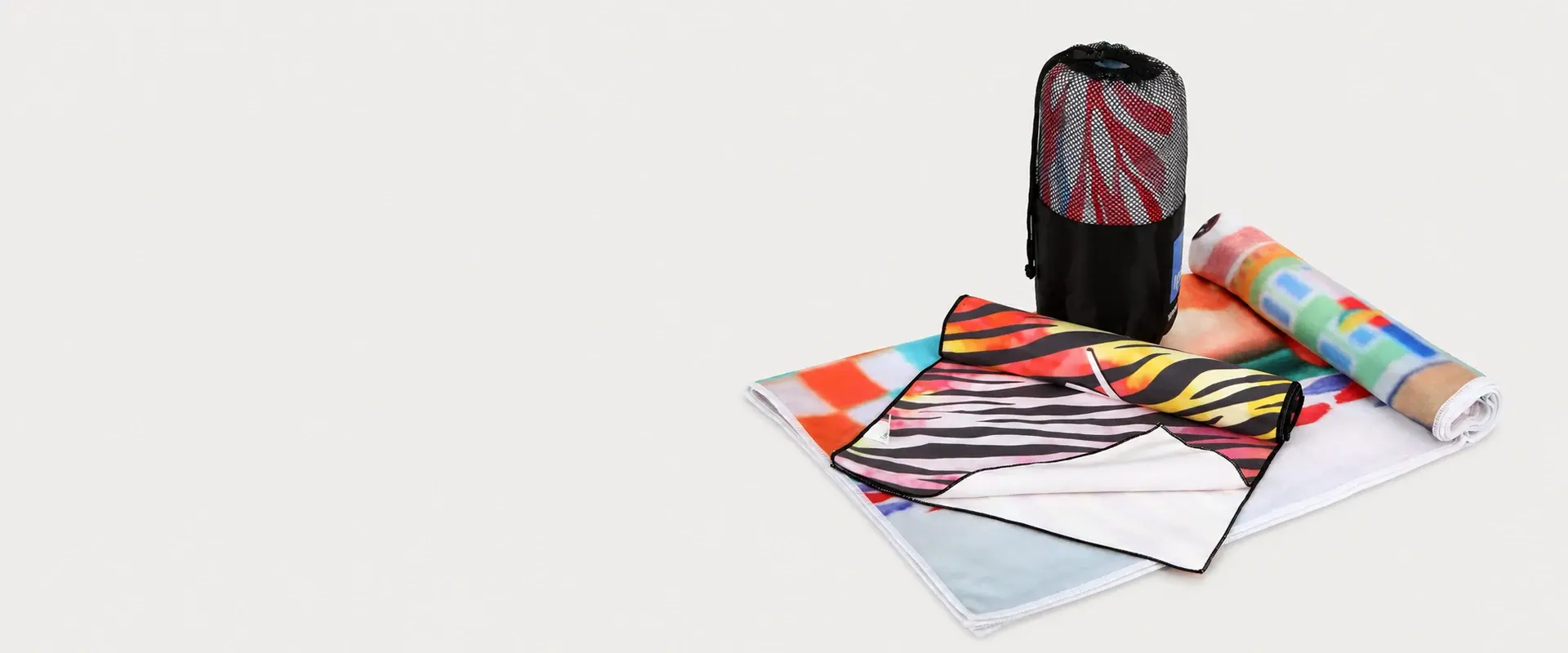 Custom printed microfiber towels and mesh storage bag arranged for branded towel project examples