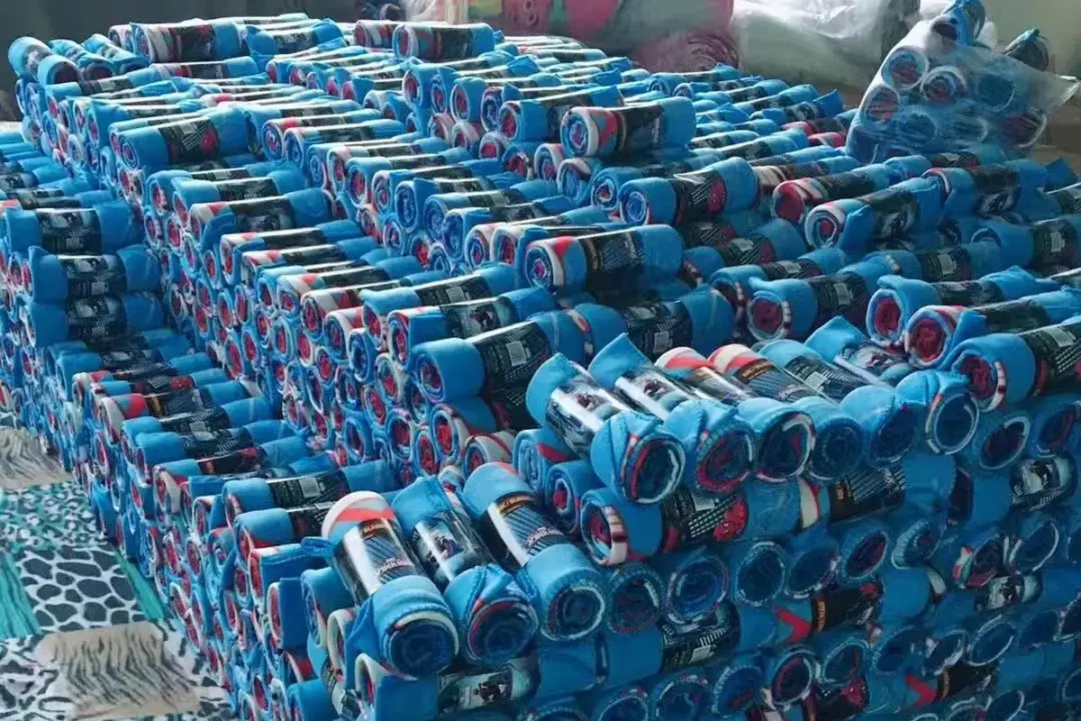 Large finished order of rolled blue sports towels prepared in the factory