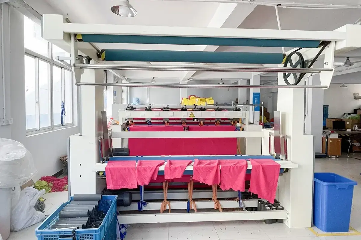 Factory printing equipment processing bright pink towel fabric in bulk