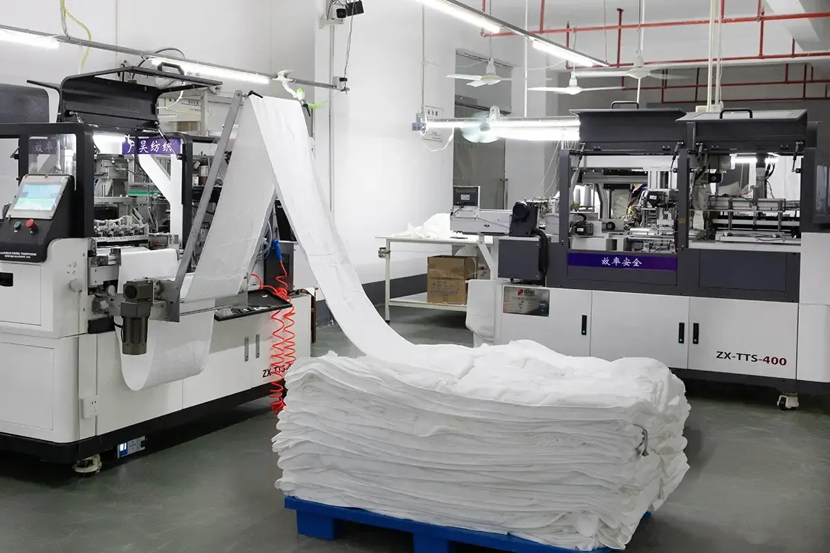 Automated factory line folding and preparing stacked white towels for packaging