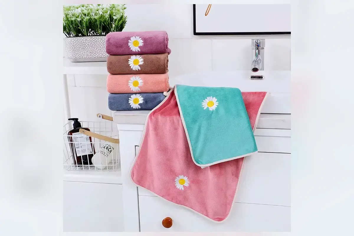 Bath towels with embroidered daisy logos in multiple colors