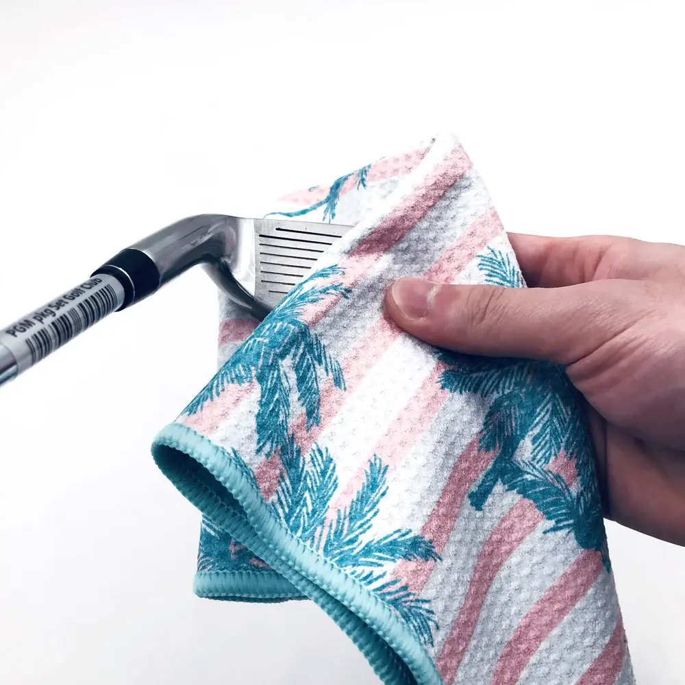 Waffle golf towel being used to clean a golf club