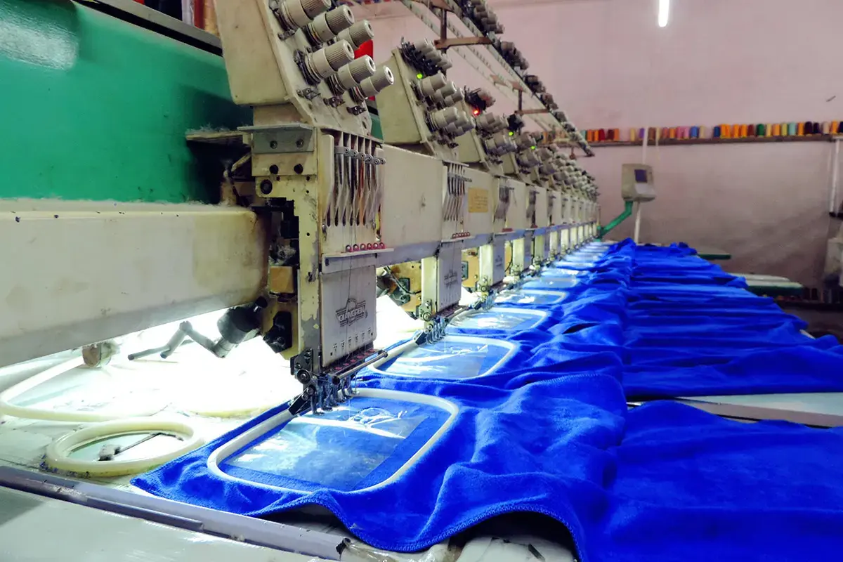 Blue towel panels under embroidery machines for thread and body color review